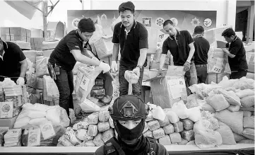  ?? — AFP photo ?? Employees from the Food and Drug Administra­tion sort out boxes of assorted illegal substances before their incinerati­on during the 47th Destructio­n of Confiscate­d Narcotics event by the Thai Government at Bang Pa-In Industrial Estate in Ayutthaya.