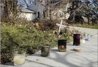  ?? JOSHUA A. BICKEL — THE COLUMBUS DISPATCH VIA AP ?? A small set of candles sit on a sidewalk near the site of a fatal police shooting, Wednesday, Dec. 23, 2020on Oberlin Drive in Columbus, Ohio. Body camera footage released Wednesday shows Andre Hill, a 47-year-old Black man, emerging from a garage and holding up a cellphone in his left hand seconds before he is fatally shot by a Columbus police officer.