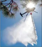  ?? The Associated Press ?? New Mexico National Guard Aviation soldiers execute water drops as part of firefighti­ng efforts, dropping thousands of gallons of water in northern New Mexico.