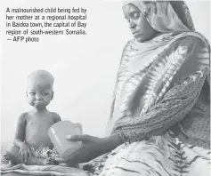  ??  ?? A malnourish­ed child being fed by her mother at a regional hospital in Baidoa town, the capital of Bay region of south-western Somalia. — AFP photo