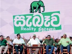  ?? ?? COMEBACK: Ranil Wickremesi­nghe, flanked by UNP deputy leader Ruwan Wijewarden­e to his right and Akila Kariyawasa­m to his left, sit beneath the party’s towering elephant symbol and election theme ‘SABAWA’ or Reality.