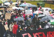  ?? ALLEN MCINNIS / POSTMEDIA NEWS ?? A small crowd braves the rain in Montreal on Sunday to
march against racism and Quebec’s Bill 21.