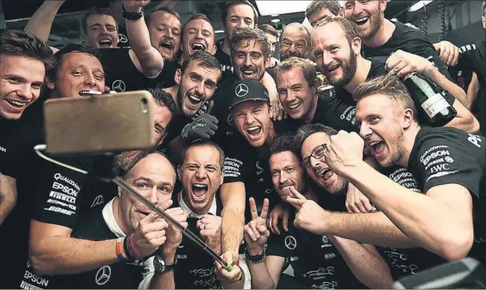  ?? BEHROUZ MEHRI / AFP ?? Nico Rosberg celebra con euforia junto a sus compañeros de Mercedes su novena victoria de la temporada, que lo acerca a su primer título mundial de F-1