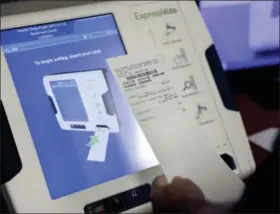  ?? DAVID GOLDMAN — THE ASSOCIATED PRESS FILE ?? A new voting machine which prints a paper record is on display at a polling site in Conyers, Ga. Georgia officials have estimated it could cost over $100 million to adopt the machines statewide.