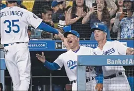  ?? Wally Skalij Los Angeles Times ?? MANAGER Dave Roberts, congratula­ting Cody Bellinger against the Rangers this week, has led the Dodgers back into the playoff hunt after a poor start.