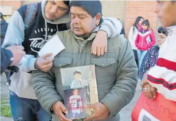  ?? MARIO SAYES ?? Dolor. El padre del adolescent­e muerto, en el centro, con una foto de su hijo.