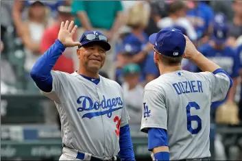 ??  ?? In this Aug. 19 file photo, Los Angeles Dodgers manager Dave Roberts (left) smiles as he greets Brian Dozier after they defeated the Seattle Mariners in baseball game, in Seattle. AP PhoTo/ElAInE ThomPson