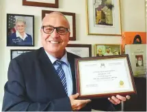  ?? Abdul Rahman/Gulf News ?? Dr Elias Sayah displays the certificat­e he received from the Abu Dhabi Judiciary Department.