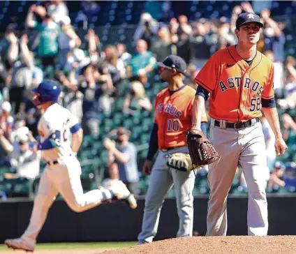  ?? Photos by Abbie Parr / Getty Images ?? Astros reliever Brooks Raley reacts after giving up a two-run homer to the Mariners’ Ty France in the fifth inning on Sunday.