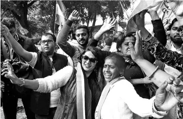  ??  ?? India’s Congress party supporters celebrate outside the party headquarte­rs in New Delhi as vote counting in five Indian states began. — AFP photo