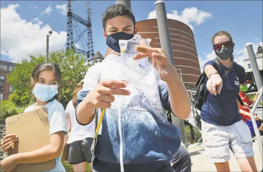  ?? Erik Trautmann photos / Hearst Connecticu­t Media ?? Joshua Browning, center, and other summer campers with the Maritime Aquarium Ocean Discovery Team check river- water chemistry off the aquarium dock Tuesday in Norwalk.