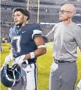  ?? ?? UConn’s Tre Wortham walks off the field at the end of the game with interim head coach Lou Spanos after losing to Wyoming on Saturday at Pratt & Whitney Stadium at Rentschler Field in East Hartford.