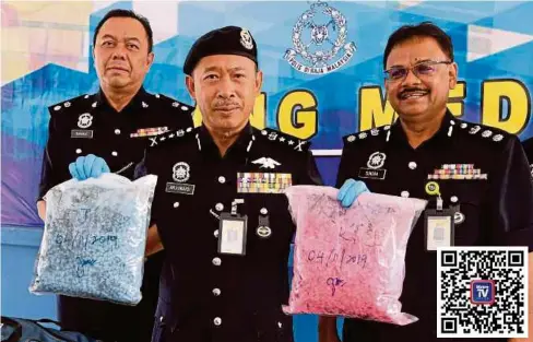  ??  ?? ARJUNAIDI (tengah) menunjukka­n pil ekstasi yang dirampas dalam tiga serbuan di IPD Daerah Klang Selatan, semalam.