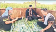  ?? ?? Leo playing a folk game (using stones) with two Dusun rice-growers in a hut in Kota Belud.