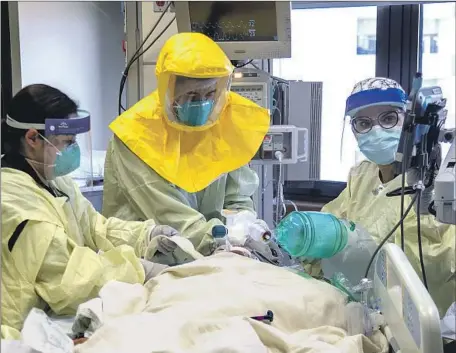  ?? Gina Ferazzi Los Angeles Times ?? PULMONOLOG­IST Dr. Laren Tan, center, with a team of nurses and respirator­y therapists, intubates a COVID- 19 patient Dec. 15 in the ICU at Loma Linda University Medical Center in the Inland Empire. The region is experienci­ng a major increase in COVID- 19 patients.