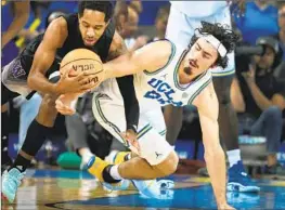  ?? Allen J. Schaben Los Angeles Times ?? JAIME JAQUEZ JR., right, battles for a loose ball against Washington’s PJ Fuller II in the second half. Jaquez led a balanced UCLA offense with 15 points.