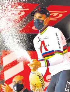  ?? - AFP photo ?? Ganna sprays champagne as he celebrates on the podium of the fourteenth stage of the Giro d’Italia 2020 cycling race, a 34,1-kilometer individual time trial between Conegliano and Valdobbiad­ene.