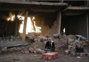  ?? AP/FELIPE DANA ?? A man selling chicken in Hajin, Syria, sits Saturday in an area that the U.S.-backed Syrian Democratic Forces recently recaptured from Islamic State militants.