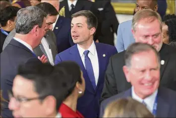  ?? Alex Wong / Getty Images ?? Transporta­tion Secretary Pete Buttigieg greets members of the U.S. Conference of Mayors on Friday during an event in the East Room of the White House.