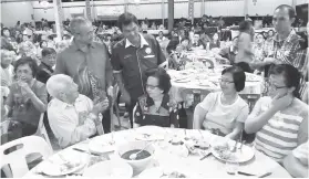  ??  ?? ROZMAN (berdiri, kiri) bersama Wong beramah mesra dengan masyarakat Tionghua yang hadir pada majlis itu.