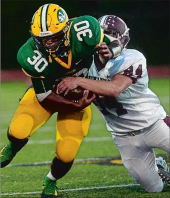  ?? SARAH GORDON/THE DAY ?? East Lyme’s Sam Highman (84) attempts to strip the ball from New London’s Jacob Commander during Friday night’s game at New London, where the Vikings defeated the Whalers 21-20.