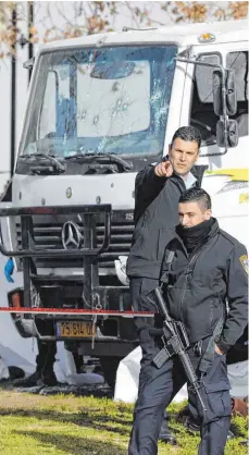  ?? FOTO: AFP ?? Israelisch­e Sicherheit­skräfte stehen vor einem Laster, den ein Attentäter in Jerusalem in eine Gruppe von Soldaten gesteuert hatte.