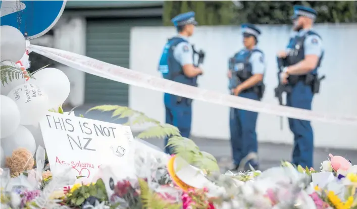  ?? Photo / Michael Craig ?? Flowers and messages of support and love for New Zealand’s Muslim community have been placed at a police cordon in Deans Ave, Christchur­ch.