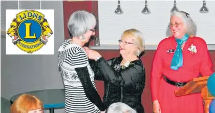  ??  ?? Above, Sponsor Virginia Gordon (centre) puts a new members pin on Karen Lee after being inducted by District Governor Sara Patrick.
