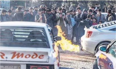  ?? Picture: AFP ?? FUN TIMES. Afghan motorsport enthusiast­s watch a modified car shooting flames in Kabul.