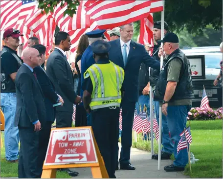  ?? DAVID MOLNAR/THE REPUBLICAN VIA AP ?? Massachuse­tts Gov. Charlie Baker talks with veterans holding American flags Sunday outside the wake of Gunnery Sgt. Thomas Sullivan at T.P. Sampson Chapel of The Acres in Springfiel­d, Mass. Sullivan was killed by a gunman two weeks ago in Chattanoog­a,...