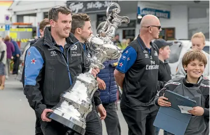  ?? PHOTO: RICKY WILSON/STUFF ?? Joseph Sullivan holds the America’s Cup as he and the team walk down High St in Picton.