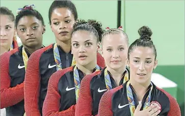  ?? Dmitri Lovetsky Associated Press ?? GABBY DOUGLAS, fourth from right, was accused by some of not acting with the proper patriotism.