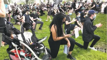  ?? Matt O'Brien / Associated Press ?? Anjel Newmann scans her phone during a rally in Providence, R.I., last week. Newmann says she’s mostly using Instagram and Facebook to organize protests while people younger than her are using Snapchat.