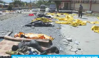  ??  ?? PALU: Tsunami survivor Ahmad Ibrahim looks for his wife Fahria amongst bodies lined up outside Undata hospital in Palu in Central Sulawesi yesterday, four days after a strong earthquake and tsunami hit the area. — AFP