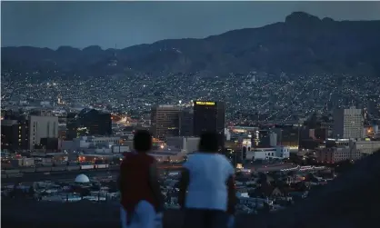  ??  ?? People look out at the lights of El Paso and Ciudad Juárez, Mexico. As one former border patrol agent wrote, the lights reach ‘across the border to form a single, throbbing metropolis’. Photograph: Joe Raedle/Getty Images