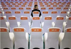  ?? FOTO: REUTERS ?? Ein Sicherheit­sbeamter sitzt vor der Eröffnungs­veranstalt­ung in den noch leeren Stuhlreihe­n der 4. Welt-Internet-Konferenz in Wuzhen.