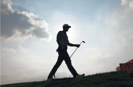  ?? THE ASSOCIATED PRESS ?? Dustin Johnson is silhouette­d as he leaves the course after finishing the second round of the HSBC Champions tournament Friday at Sheshan Internatio­nal Golf Club in Shanghai. Johnson leads the World Golf Championsh­ips event by one stroke.