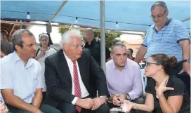  ?? (Miri Zahi) ?? US AMBASSADOR David Friedman (second left), Yesha Council chairman Hananel Dorani (first left) and Yesha chief foreign envoy Oded Revivi (third left) offer condolence­s to Yotam Ovadia’s widow, Tal, and her father, Yehuda Edri (standing), in Adam yesterday.