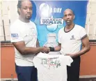  ??  ?? Rohan Phillips (right), second-place winner in the burpees challenge, getting his gift from The Gleaner’s Fit 4 Life fitness coach, Marvin Gordon.