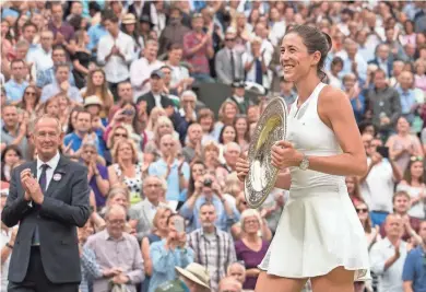  ?? SUSAN MULLANE / USA TODAY SPORTS ?? Garbine Muguruza leaves the court with the trophy after defeating Venus Williams in straight sets in the women’s final.