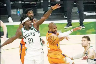  ??  ?? Phoenix Suns guard Chris Paul, (center), fights for a rebound with Milwaukee Bucks guard Jrue Holiday (21) and center Brook Lopez, (right), during the first half of Game 4 of basketball’s NBA Finals in Milwaukee. (AP)