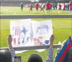  ?? JORDI COTRINA ?? Un nen mostra un dibuix de Messi en un entrenamen­t del Barça.