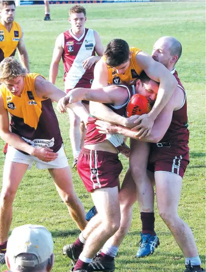  ??  ?? Drouin’s best player on Saturday Luke Duffy wasn’t letting a Traralgon opponent get anywhere with the ball as he wrapped him up in a typically strong tackle close to the boundary line. At left is Drouin team mate Brad Williams.