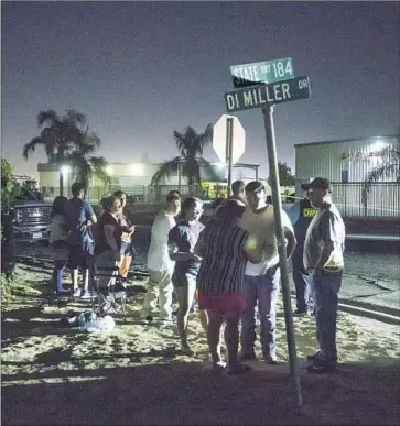  ?? Felix Adamo Bakersfiel­d California­n ?? PEOPLE gather near the site in Bakersfiel­d where several people were shot and killed Wednesday. Six people, including the gunman, died in the rampage, the third-deadliest shooting in the nation this year.