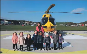  ?? Photograph: Kenny Craig. ?? Catherine Black and children from Dalintober Early Learning Centre welcomed the first helicopter’s crew to the Robert Black Memorial Helipad.