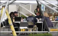  ?? Associated PRess ?? Shooting: Law enforcemen­t officials work under a tent, Saturday outside the Cascade Mall in Burlington, Wash. Authoritie­s said Saturday several people were dead after the shooting Friday night and the suspect was still at large.