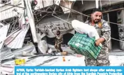  ?? —AFP ?? AFRIN, Syria: Turkish-backed Syrian Arab fighters loot shops after seizing control of the northweste­rn Syrian city of Afrin from the Kurdish People’s Protection Units (YPG).