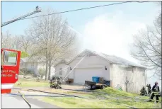  ?? Keith Bryant/The Weekly Vista ?? Firefighte­rs battle a house fire at 3 Cheddar Drive. Battalion Chief Robert Hamilton said that the fire appeared to be caused by embers from a controlled burn that wind carried to the deck.