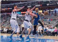  ?? Reuters ?? Warriors’ Michael McAdoo looks to pass the ball around Mavericks’ Nicolas Brussino and Salah Mejri. —