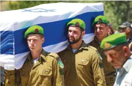  ?? (Omri Stein/Flash90) ?? NAHAL BRIGADE soldiers carry the body of their fellow comrade, Omer Tabib, 21, at a cemetery in the town of Elyakim yesterday.